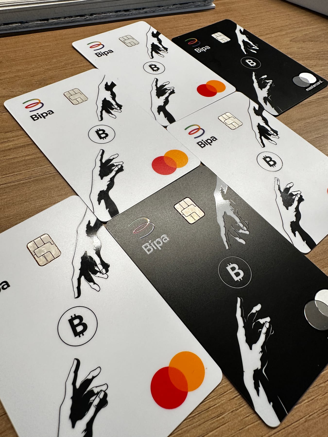Bipa physical cards, in white and black, on a wooden table